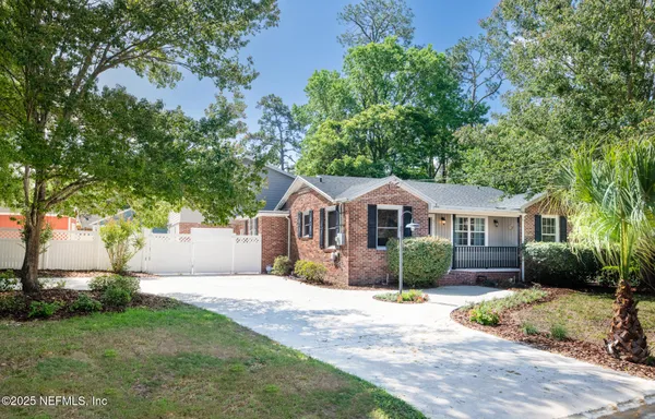 a front view of a house with a yard and trees