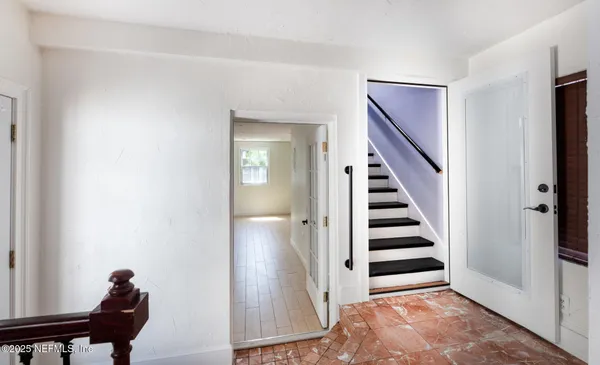 a view of a hallway with entryway and stairs