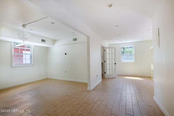an empty room with a window and a ceiling fan