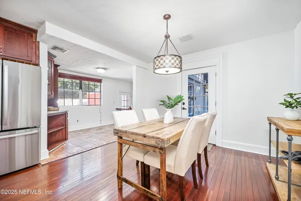 a view of a dining room with furniture a chandelier and wooden floor