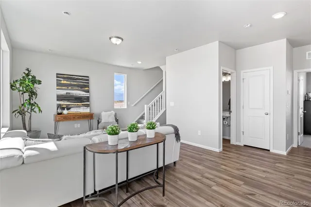 a living room with furniture and wooden floor