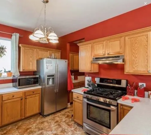 a kitchen with stainless steel appliances granite countertop a stove refrigerator and microwave