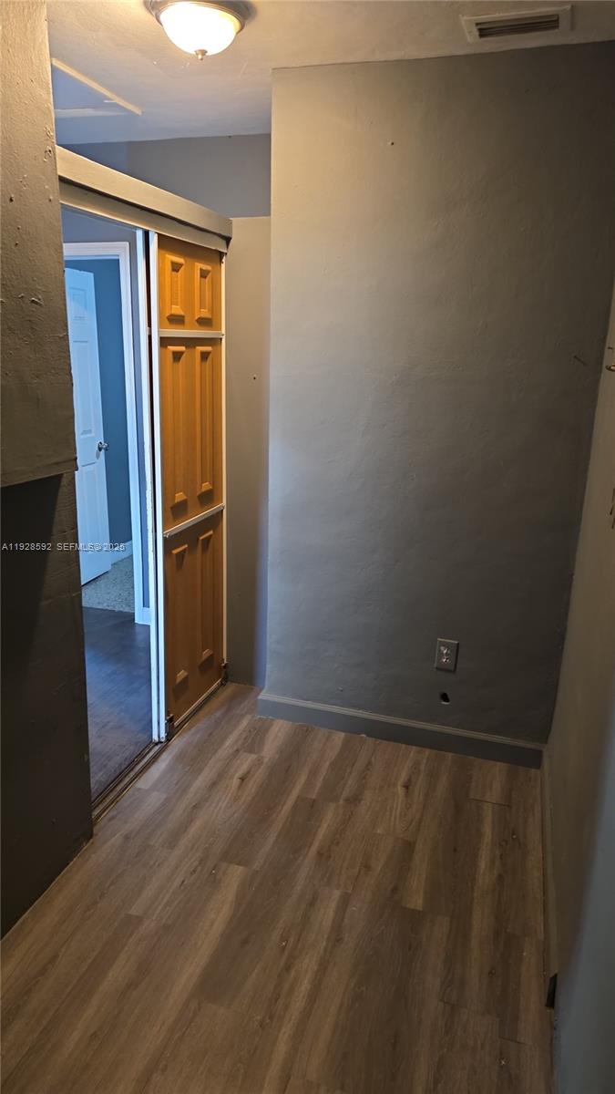 3300 Northwest 23rd Avenue, Unit 1 Miami, FL 33142 - Photo 9 of 11 a view of an empty room with wooden floor and a window
