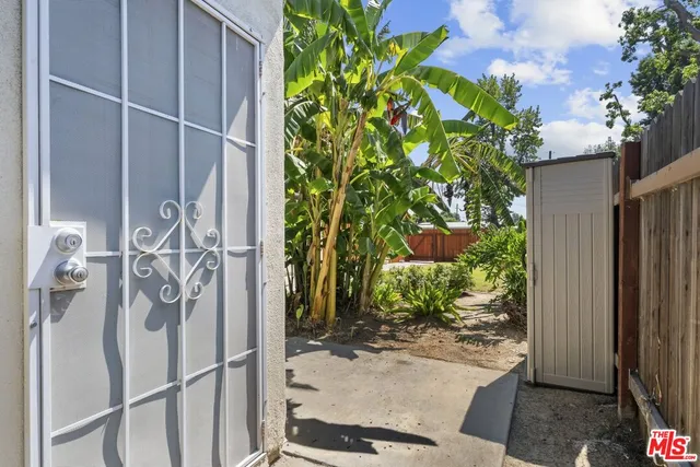 a view of backyard with table and chairs and wooden fence
