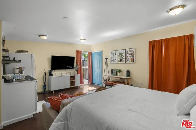 a bedroom with a bed and a flat screen tv