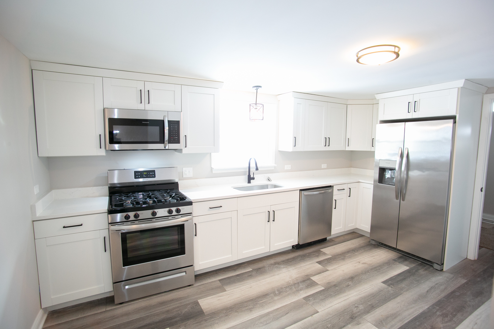 15039 Copter Lane Romeoville, IL 60446 - Photo 6 of 17 a kitchen with a stove a sink and a refrigerator