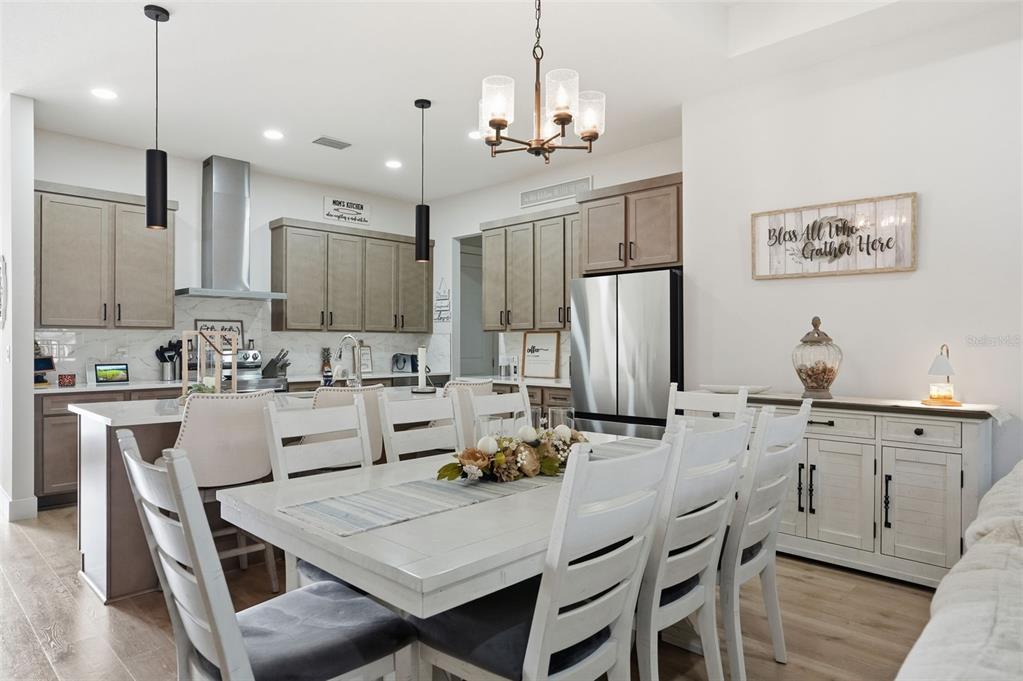 9013 Mississippi Run Weeki Wachee, FL 34613 - Photo 19 of 99 a kitchen with stainless steel appliances kitchen island granite countertop a table chairs and a refrigerator