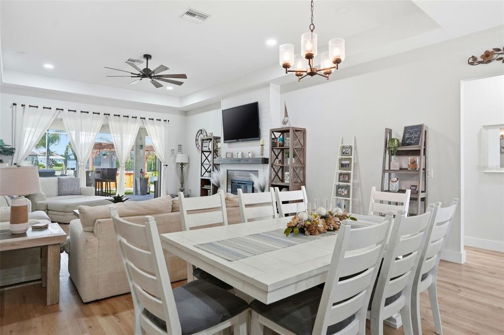 9013 Mississippi Run Weeki Wachee, FL 34613 - Photo 20 of 99 a view of a dining room with furniture a flat screen tv and chandelier