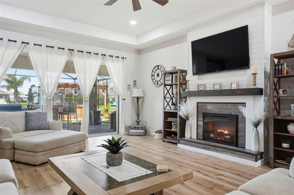9013 Mississippi Run Weeki Wachee, FL 34613 - Photo 23 of 99 a living room with furniture a flat screen tv and a fireplace