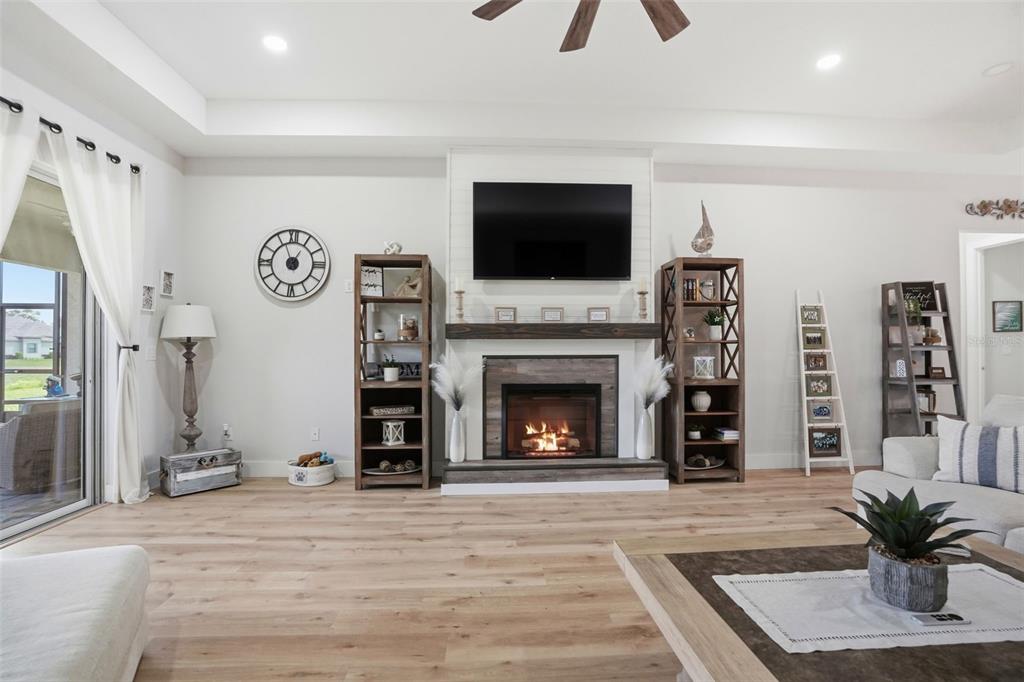 9013 Mississippi Run Weeki Wachee, FL 34613 - Photo 26 of 99 a living room with furniture a flat screen tv and a fireplace