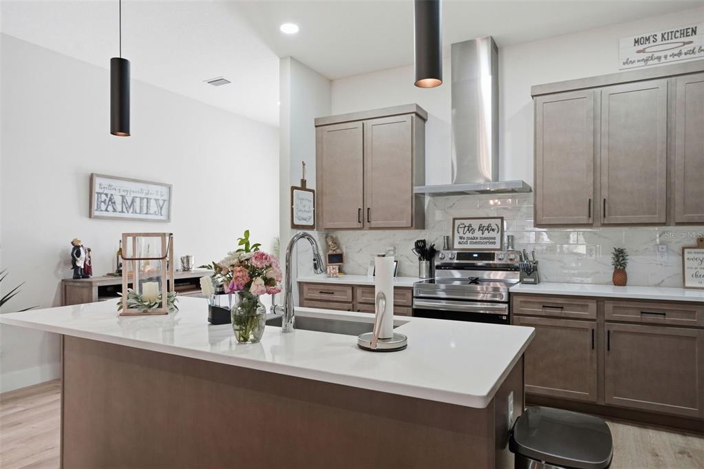 9013 Mississippi Run Weeki Wachee, FL 34613 - Photo 6 of 99 a kitchen with kitchen island granite countertop a sink a stove and cabinets