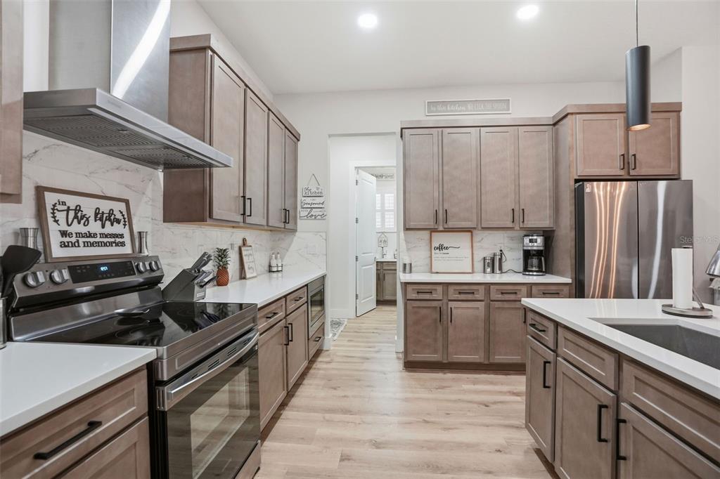 9013 Mississippi Run Weeki Wachee, FL 34613 - Photo 8 of 99 a kitchen with kitchen island granite countertop a sink cabinets and stainless steel appliances