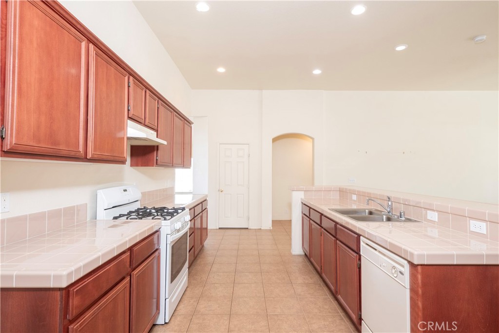 21189 Colombard Way Apple Valley, CA 92308 - Photo 11 of 48 a kitchen with stainless steel appliances granite countertop a sink and a stove