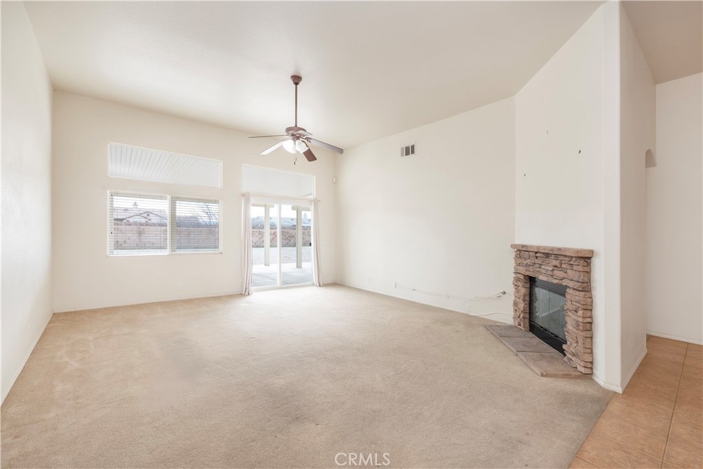 21189 Colombard Way Apple Valley, CA 92308 - Photo 13 of 48 an empty room with windows and fireplace
