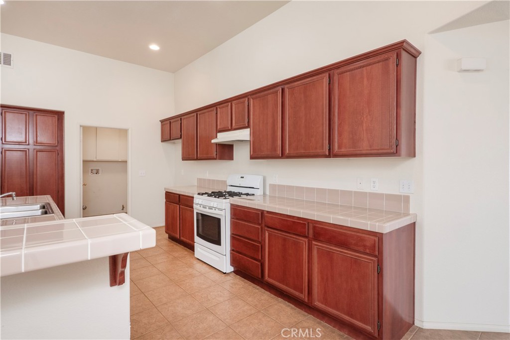 21189 Colombard Way Apple Valley, CA 92308 - Photo 6 of 48 a kitchen with stainless steel appliances granite countertop a sink stove and refrigerator