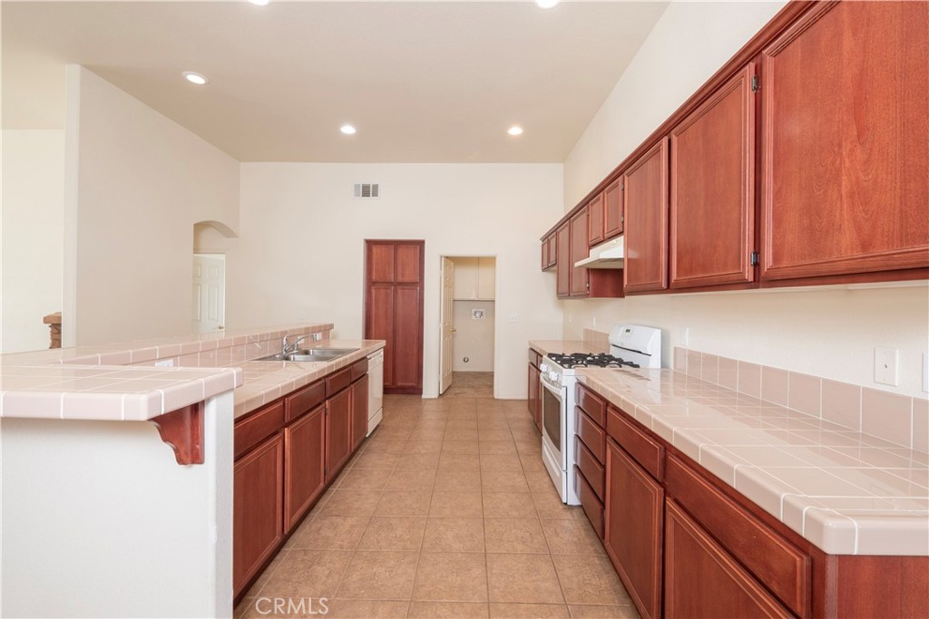 21189 Colombard Way Apple Valley, CA 92308 - Photo 7 of 48 a large kitchen with stainless steel appliances granite countertop a stove and a sink
