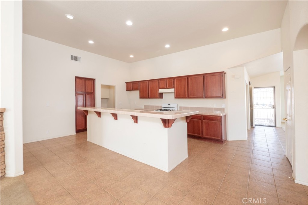 21189 Colombard Way Apple Valley, CA 92308 - Photo 9 of 48 a large white kitchen with kitchen island a sink a stove and a refrigerator