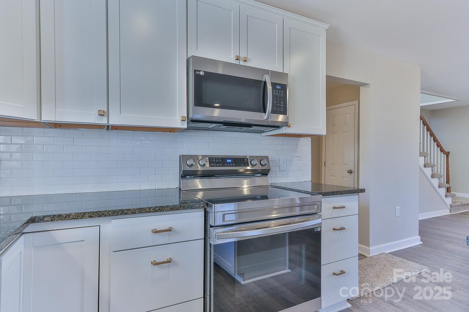3424 Walker Circle Lenoir, NC 28645 - Photo 18 of 38 a kitchen with white cabinets and stainless steel appliances