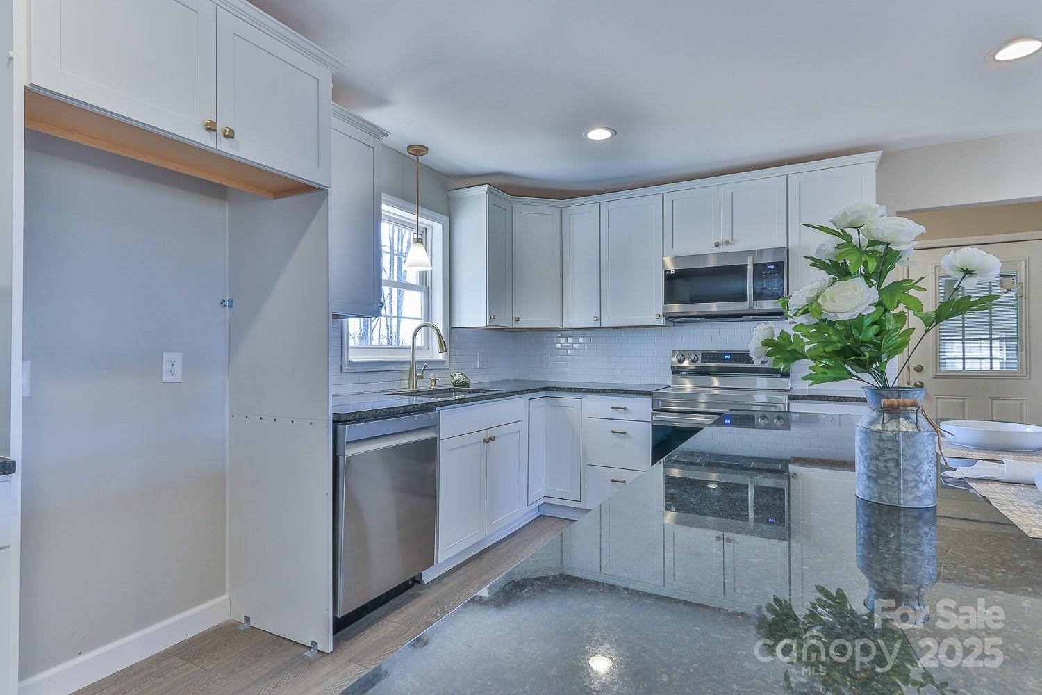 3424 Walker Circle Lenoir, NC 28645 - Photo 21 of 38 a kitchen with kitchen island granite countertop white cabinets and white appliances