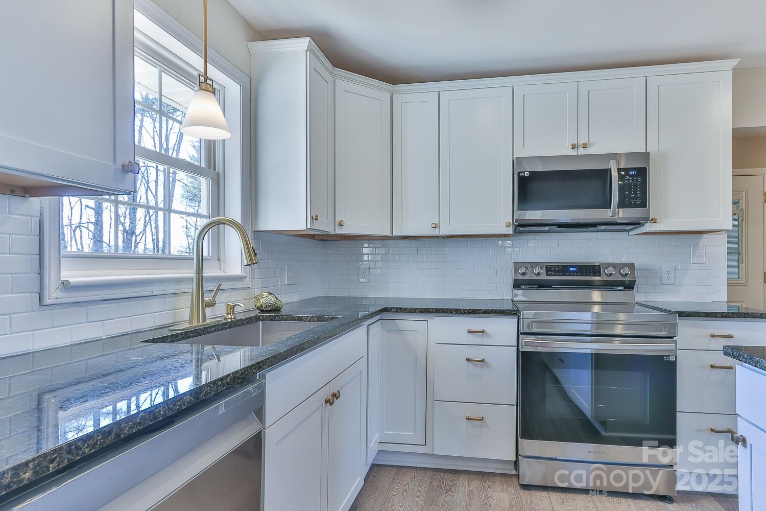 3424 Walker Circle Lenoir, NC 28645 - Photo 22 of 38 a kitchen with granite countertop a stove sink and microwave
