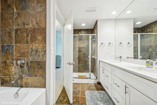 a spacious bathroom with a double vanity sink a large mirror and a shower