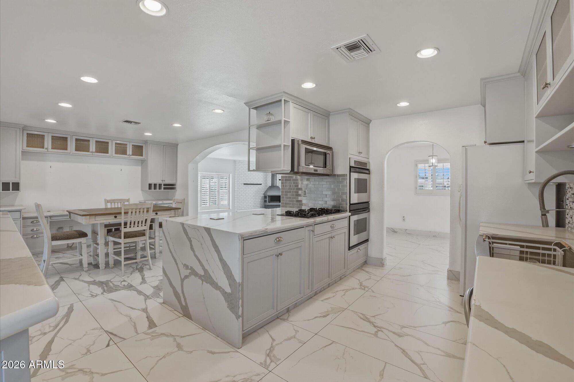 1532 West Loma Lane Phoenix, AZ 85021 - Photo 3 of 19 a large kitchen with kitchen island a table and chairs in it