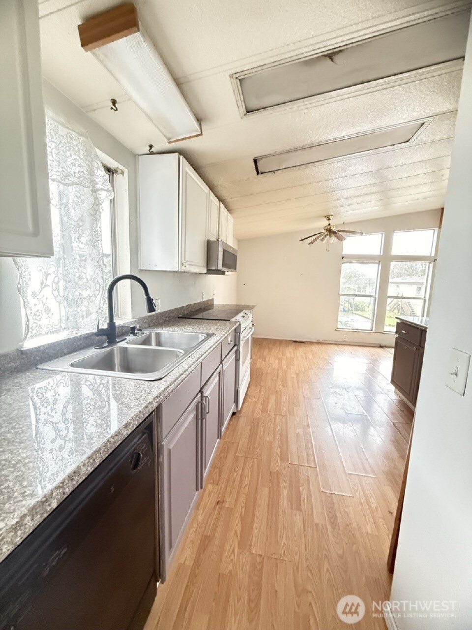 14003 70th Street East Sumner, WA 98390 - Photo 4 of 20 a kitchen with sink a window and wooden floor