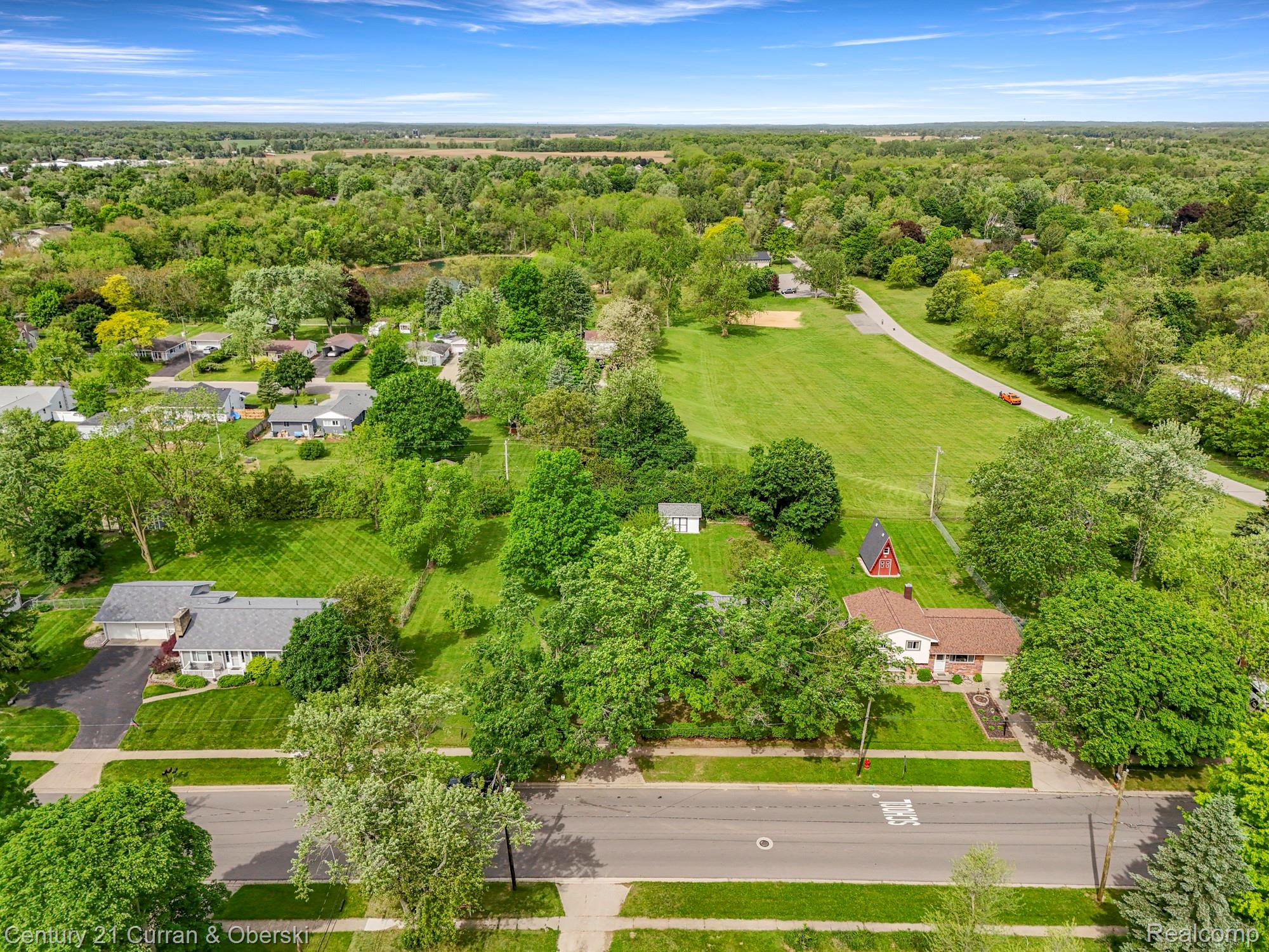 411 South Adrian Street Tecumseh, MI 49286 - Photo 55 of 61 Aerial perspective of suburban area with a heavily wooded area