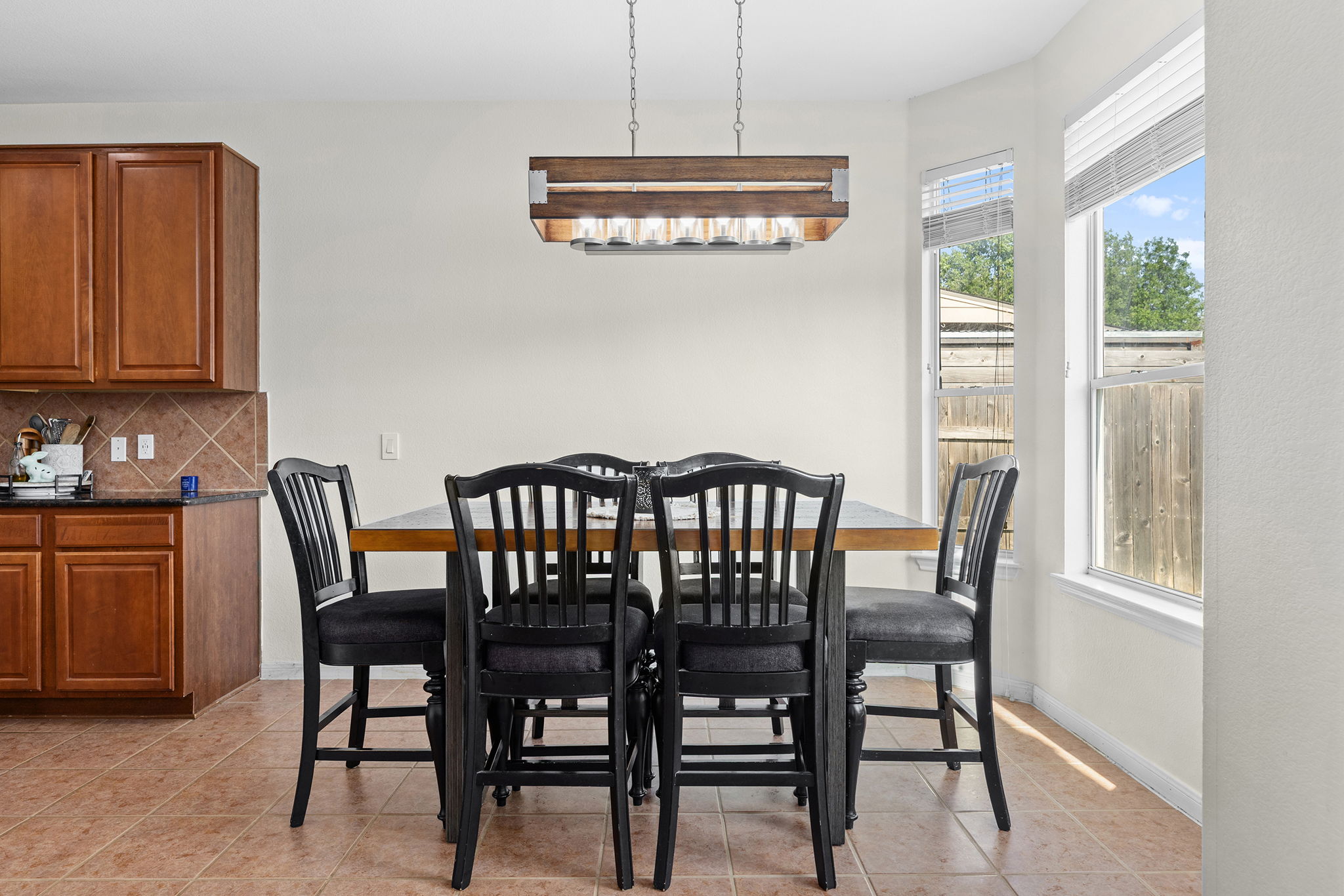3517 Shiraz Loop Round Rock, TX 78665 - Photo 14 of 40 Dining area featuring a wood-finish chandelier, bay windows, and tiled flooring