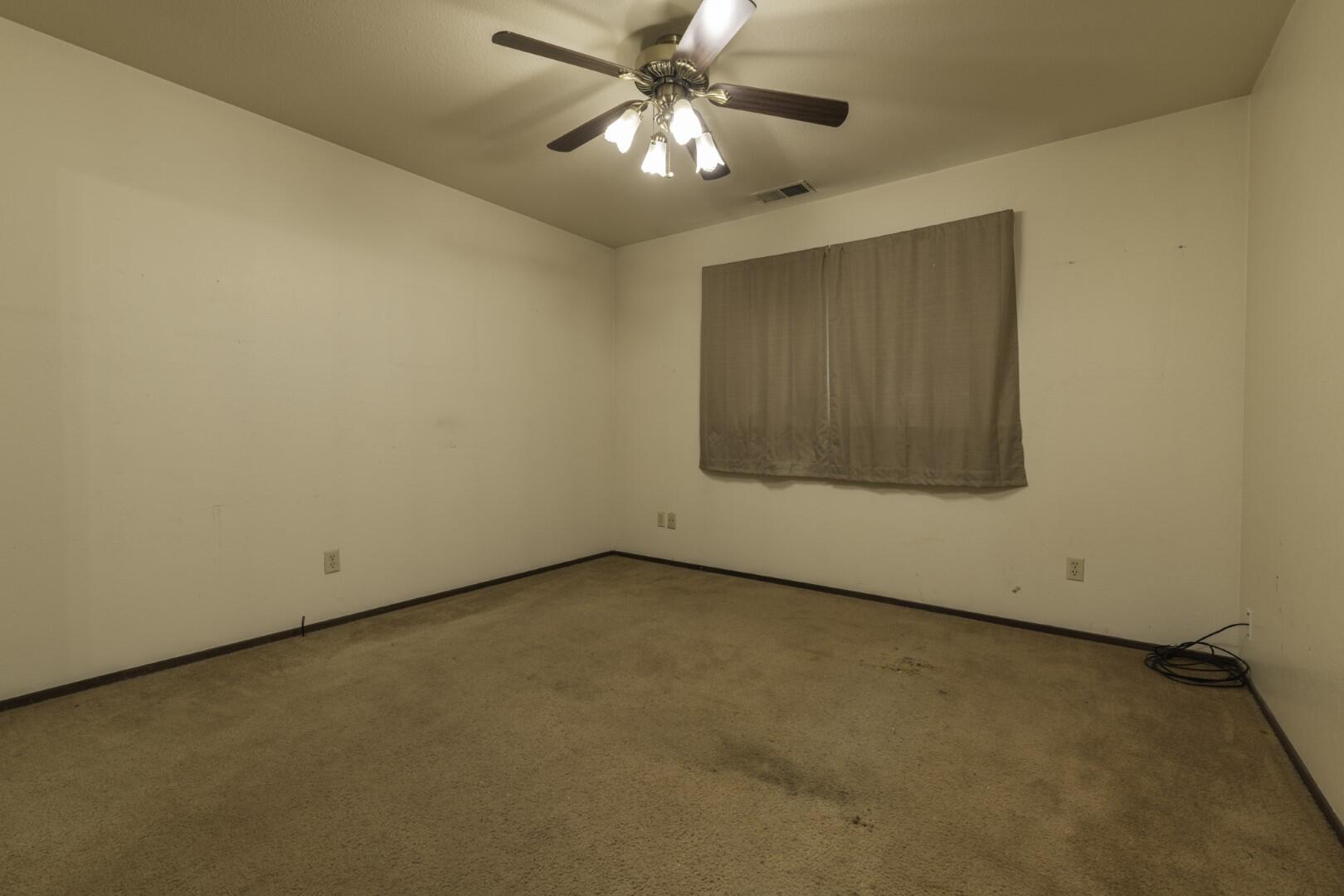 3305 Cessna Drive Redding, CA 96001 - Photo 13 of 15 an empty room with a ceiling fan and a window