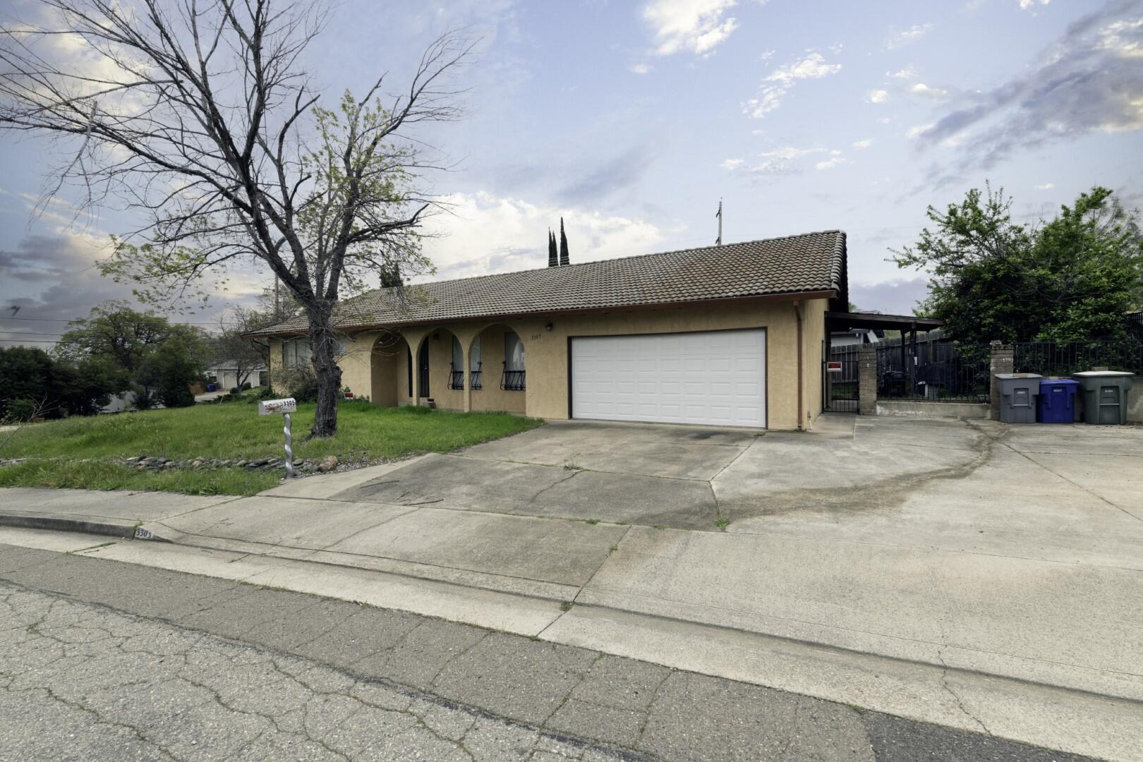 3305 Cessna Drive Redding, CA 96001 - Photo 2 of 15 a front view of a house with a yard and garage