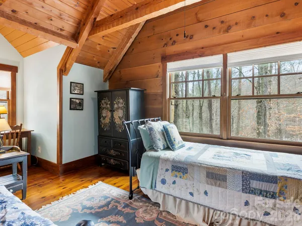 a bedroom with a bed a chandelier and a window