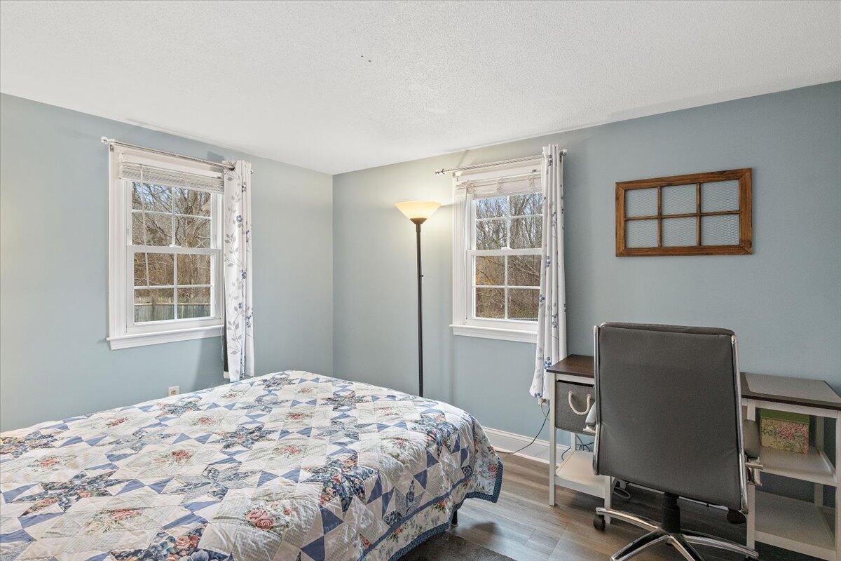 24 Regency Drive Sagamore, MA 02561 - Photo 16 of 27 a bedroom with a bed and a chair next to a window