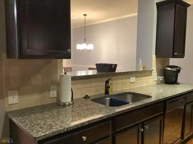 a kitchen with a sink a counter space and cabinets