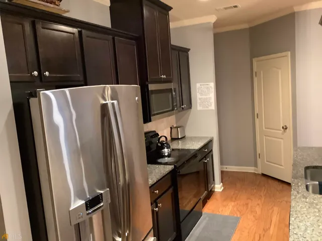 a kitchen with sink a refrigerator and a stove