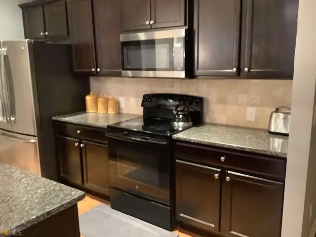 a kitchen with granite countertop cabinets and steel stainless steel appliances