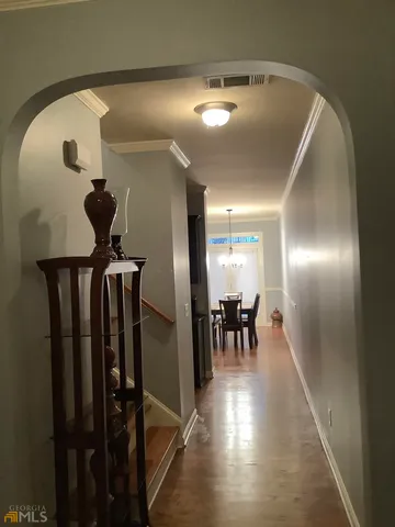 a view of a hallway with livingroom and furniture