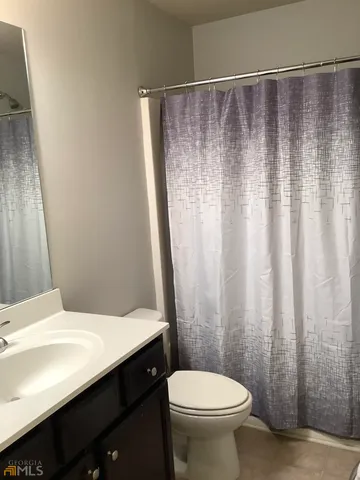 a bedroom with a bed and painting on the wall