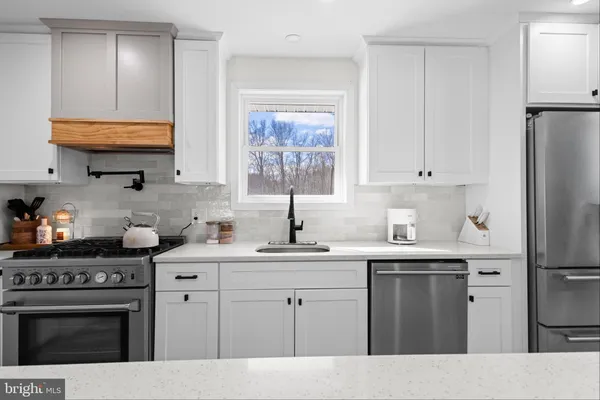 a kitchen with stainless steel appliances a sink stove and refrigerator