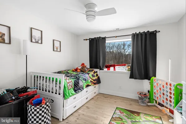 a bedroom with furniture a rug toys and a chandelier