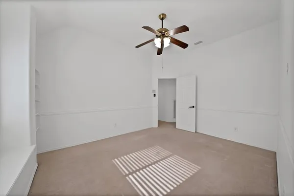 an empty room with a window and a fan