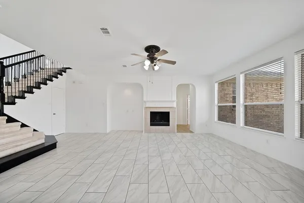a view of an empty room with a fireplace and a window
