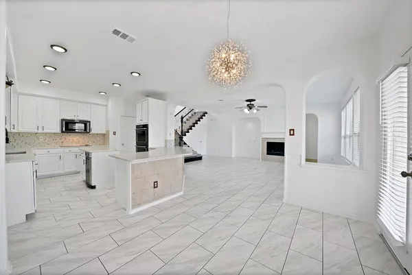 a large white kitchen with cabinets