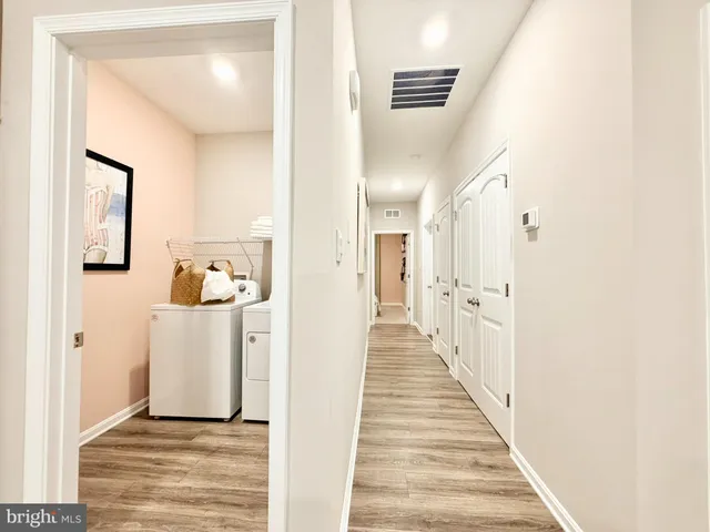 a view of a hallway with wooden floor and entryway