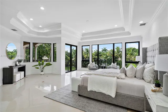 a bedroom with furniture and large windows