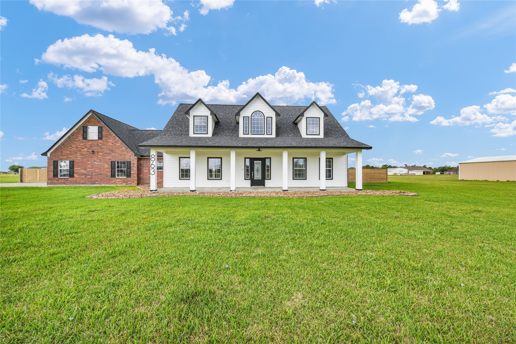 Welcome to 863 Bunkhouse Trail! This charming home features a classic design with a white facade, dormer windows, and a welcoming porch. It sits on a spacious, well-maintained lawn. Perfect for those seeking a blend of traditional style and ample outdoor space.