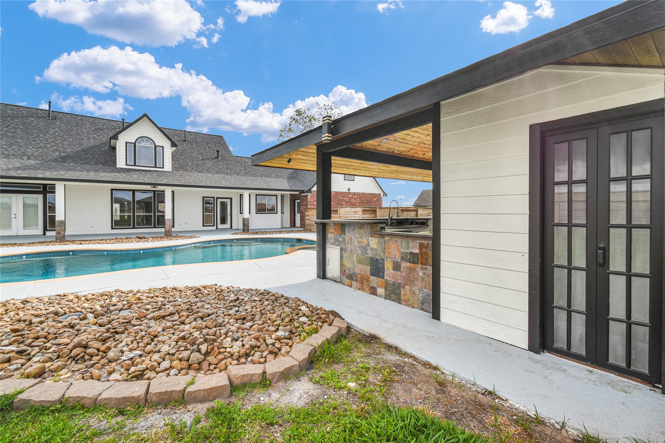 863 Bunkhouse Trail Angleton, TX 77515 - Photo 19 of 22 Side view of outdoor kitchen with entrance to half bathroom