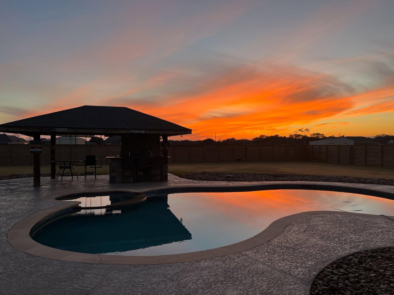 863 Bunkhouse Trail Angleton, TX 77515 - Photo 20 of 22 A stunning backyard view set against a vibrant sunset sky.