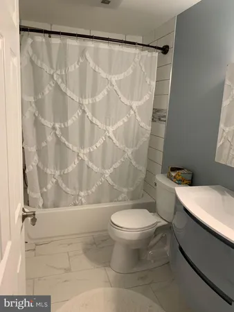 a white toilet sitting next to a shower curtain