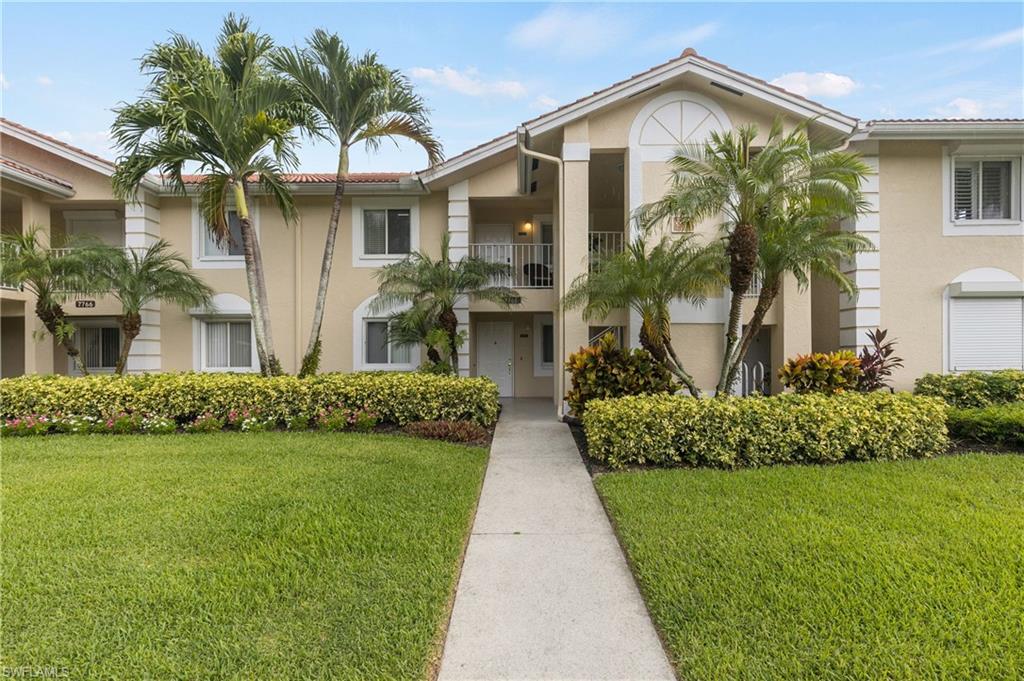 7766 Emerald Circle, Unit R203 Naples, FL 34109 - Photo 1 of 30 View of front of home featuring stucco siding, a front yard, and a tiled roof